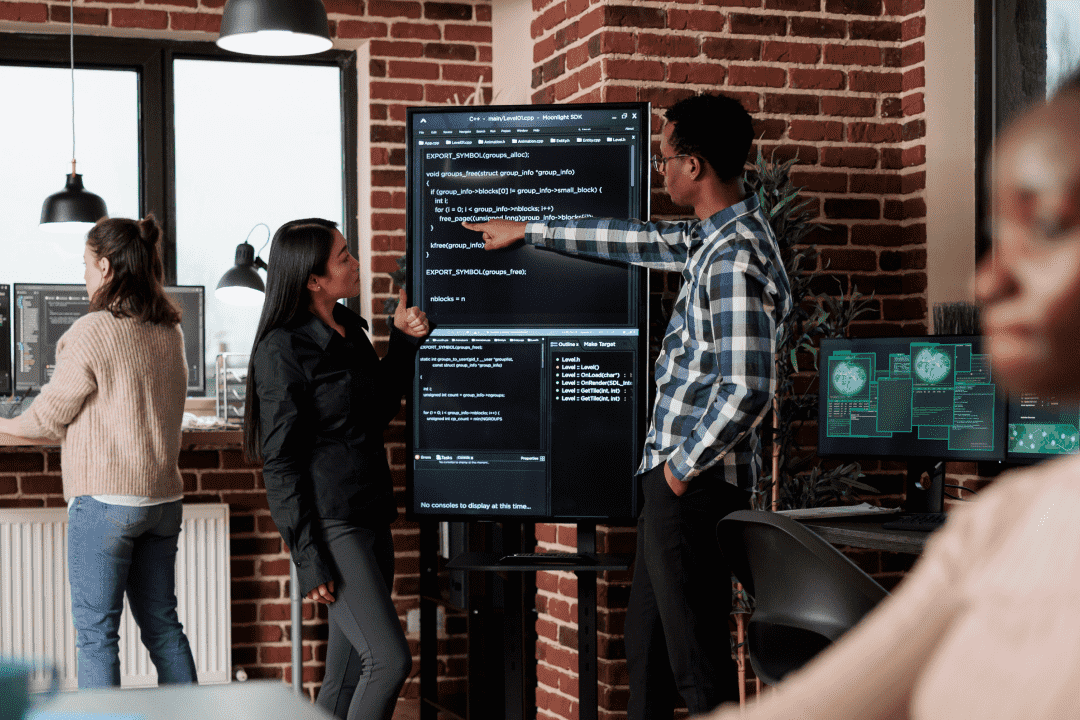 Engineering team talking while pointing at a screen