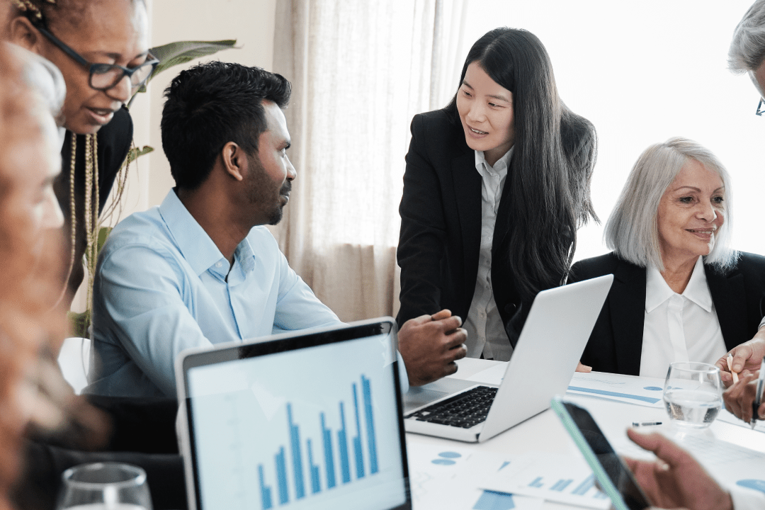 Finance team in a meeting with charts being shown in a laptop screen