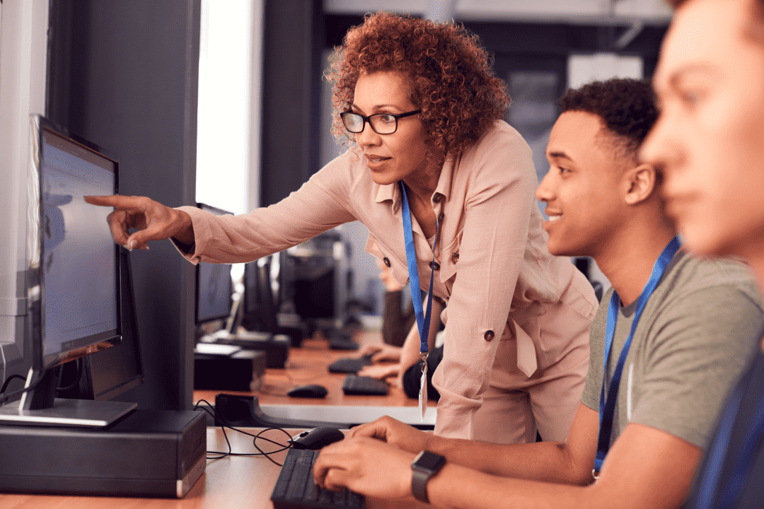 Woman helping man colleague to solve an IT issue