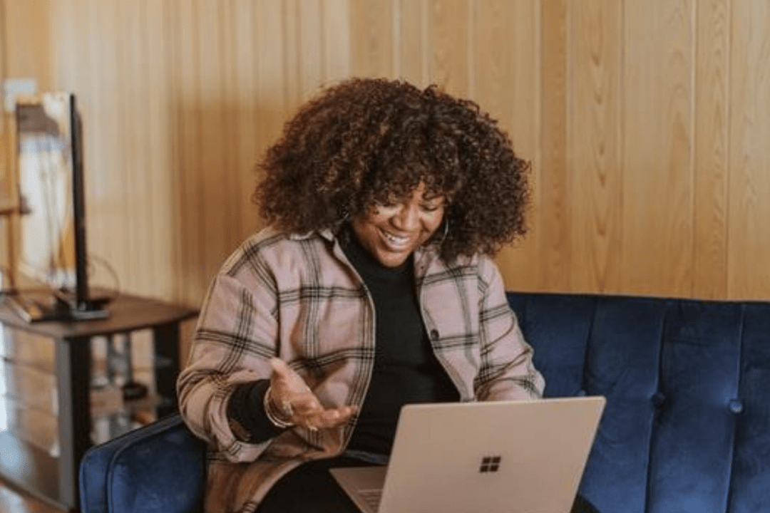 Happy woman smiling while using a laptop 